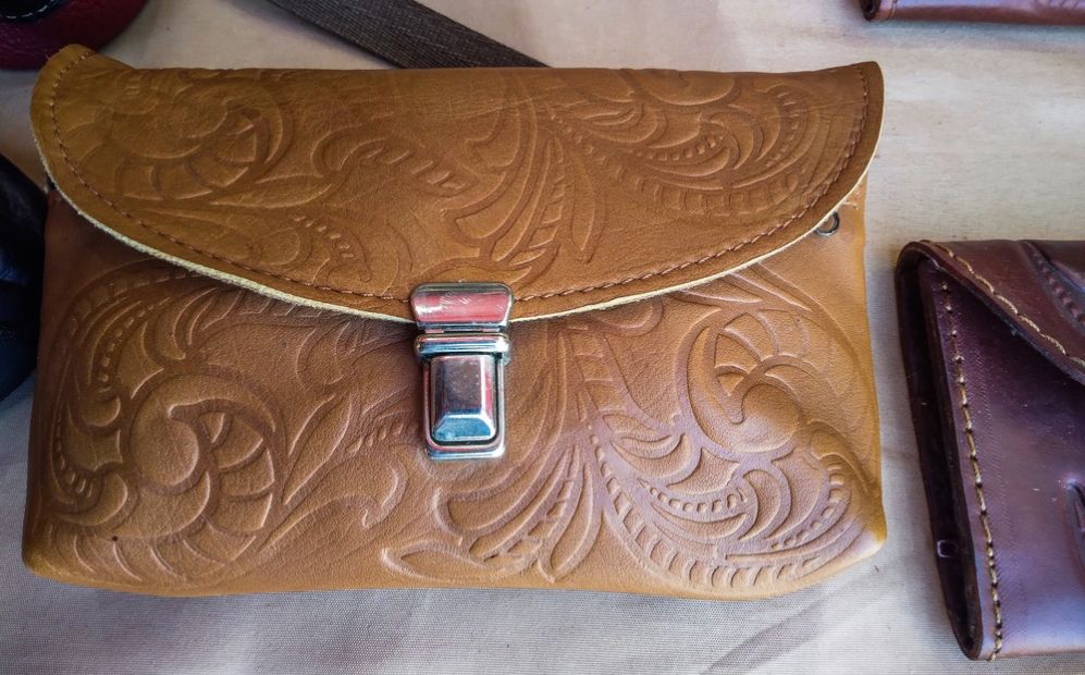 Borsa di pelle tipo clutch con decorazione e chiusura metallica realizzata con tecnologie di personalizzazione che sfruttano tecnologie di marcatura laser